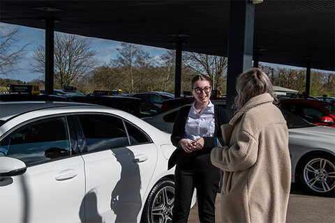 customer and salesperson talking in a car dealership