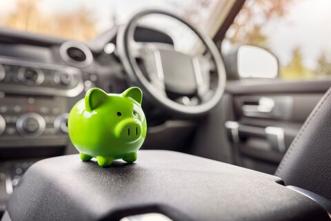 Green piggy bank in car - desktop